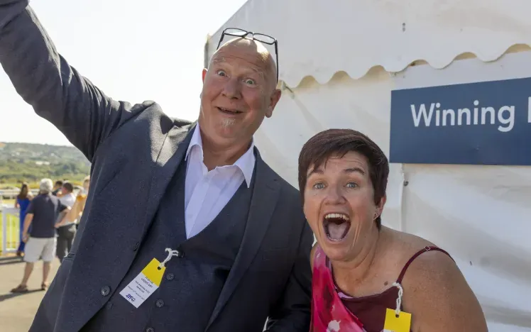 Two race goers at Ffos Las pull faces and smile for the camera