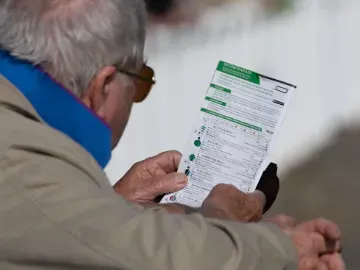 A racegoer studying the racecard at Ffos Las