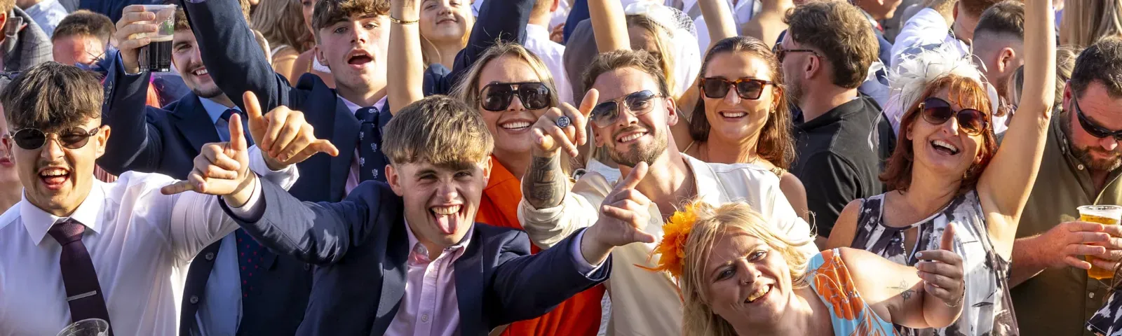 Ffos Las guests throw their hands in the air for a crowd picture