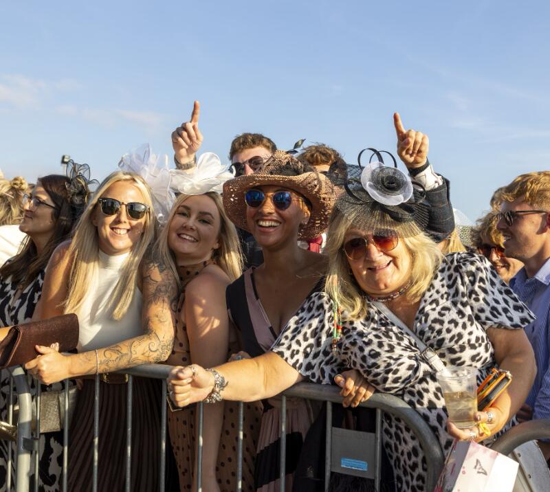 A group of friends pose in the sunshine during live entertainment at Ffos Las