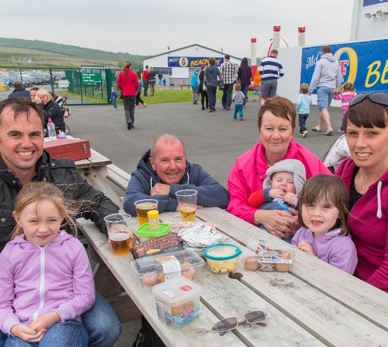 An extended family enjoy a spot of outdoor dining during a family fun day at Ffos Las Racecourse