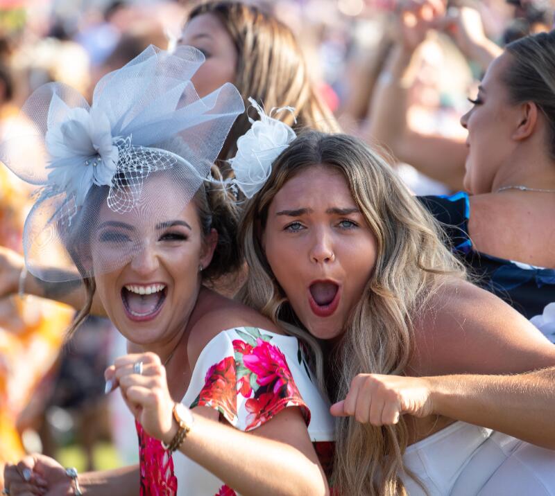 Two racegoers dancing and laughing at Ffos Las Races