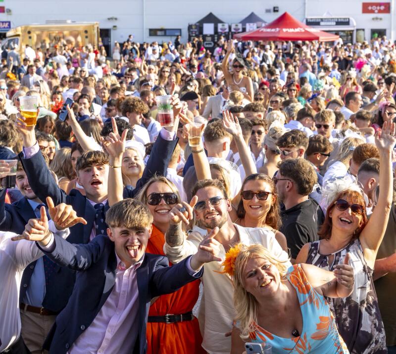 Ffos Las guests throw their hands in the air for a crowd picture