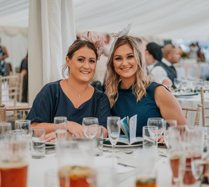 Two hospitality guests pose for the camera at Ffos Las.